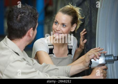 experienced female auto mechanic checking tires Stock Photo