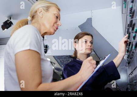 technicians maintaining record of rack mounted server Stock Photo