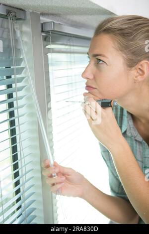 woman installing blinds with screwdriver Stock Photo