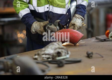 closeup on electric saw and hands of worker with sparks Stock Photo