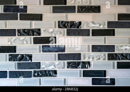 Black and white tiles in a rectangular pattern of an interior kitchen wall Stock Photo