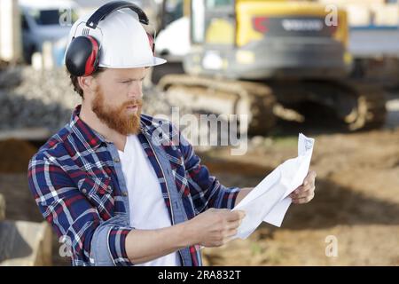 civil engineer or architect on construction site checking plan Stock Photo