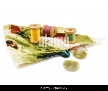 Piece of cloth, colored threads and buttons isolated on a white background Stock Photo