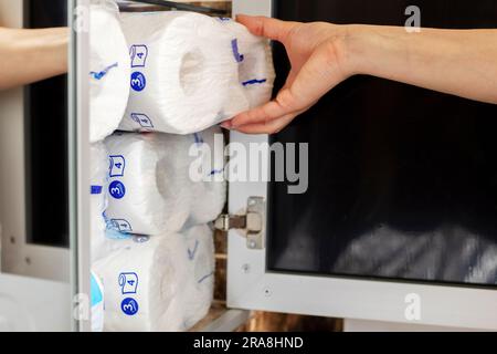 A woman is stocking up toilet paper at home.  Stock Photo