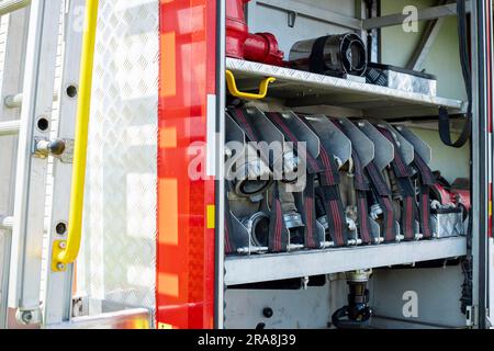Fire truck equipment. Compartment of the rolled up fire hoses on a fire engine Stock Photo
