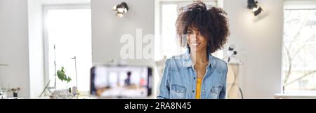 African-American female designer with sewing patterns and fabric Stock Photo