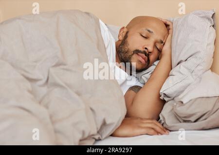 Portrait of adult black man sleeping in comfortable bed in cozy home Stock Photo