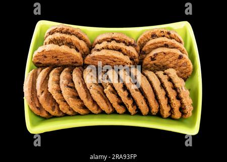 A Stack Of Delicious Chocolate Chip Cookies In Green Bowl on a Black Surface. Top View Stock Photo