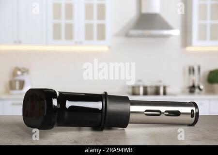 Sous vide cooker on light grey table in kitchen, space for text. Thermal immersion circulator Stock Photo