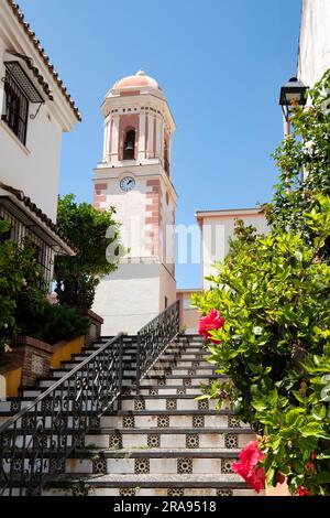 a view of the the town clock tower in the old town of Estepona, Spain. known locally as La Torre Del Reloj situated in the Plaza de la Reloj Stock Photo