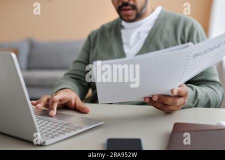 Closeup of black businessman working from home and reviewing financial documents, copy space Stock Photo