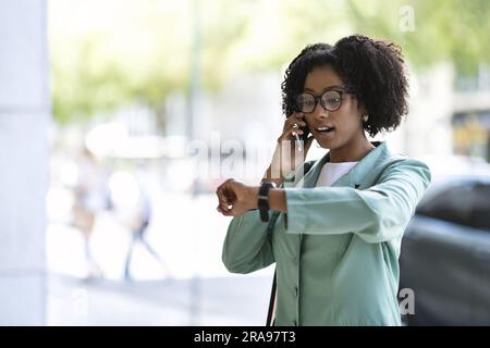 Attractive young black woman getting late for business meeting Stock Photo