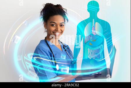 Young black woman doctor using laptop, checking patient anamnesis Stock Photo