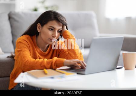 Exhausted young eastern woman freelancer working from home Stock Photo