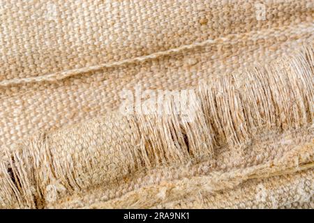 Close-up shot of worn seat fabric - appears to be mixed fibre not 100% cotton. For frayed edges, seen better days, out of condition metaphor. Stock Photo