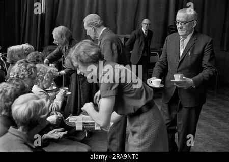 Darby and Joan Club. A blind and partially sighted afternoon dance class for senior citizens at the Battersea Institute. Cups of tea are handed around by the more able members of the class at the end of the session. Battersea, London, England circa 1970. 1970s UK HOMER SYKES Stock Photo