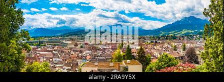 Large panorama photo overlooking Lucerne's Old Town with an impressive mountainous panorama in the back, seen from the medieval fortification wall... Stock Photo