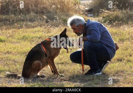 Beirut, Lebanon. 1st July, 2023. A man interacts with a dog during the 'Dogs Do Care Event' in Beirut, Lebanon, July 1, 2023. Credit: Liu Zongya/Xinhua/Alamy Live News Stock Photo