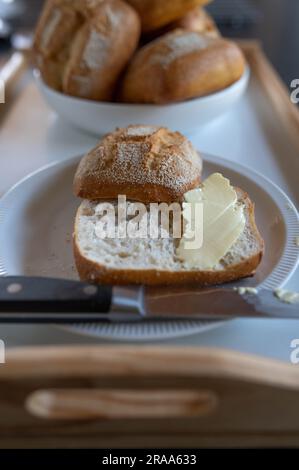 Sliced bun with butter on a plate Stock Photo