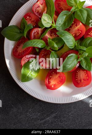 Cherry tomato salad with basil and olive oil on a plate Stock Photo