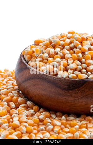Dried  corn kernels in wooden bowl isolated on white Stock Photo