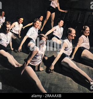 Health and beauty-a morning exercise class at Harrington Road, London, as conducted by Helen Stack(cousin of Prunella Stack)for the Women's League of Health and Beauty, at the London Academy of  Music and Dramatic Art. Here, young women demonstrate hip rolling.     Date: 1938 Stock Photo