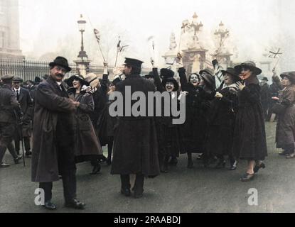 Women waving Union flags and cheering on Armistice Day 1918 at the end of World War One.     Date: 11th November 1918 Stock Photo