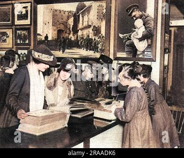 Customers inspecting picture albums at a new bureau for the sale of official war photographs opened by the Ministry of Information at Coventry Street by John Buchan in October 1918.     Date: 1918 Stock Photo