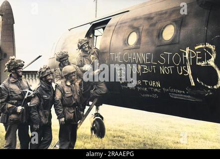 A team of paratroopers on 7 June 1944 amuse themselves whilst awaiting the call to take flight in their glider (an Airspeed Horsa) to back up the initial assault phase on the Normandy coast. The chalk slogan reads: 'The Channel stopped you, but not us - now it's our turn. You've had your time you German Schweinhunds'!  D-Day began on 6 June 1944 at 6:30am and was conducted in two assault phases û the air assault landing of allied troops followed by an amphibious assault by infantry. The Normandy landings were the largest single-day amphibious actions ever undertaken, involving close to 400,000 Stock Photo