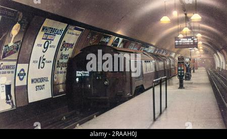 A tube a train at a london underground platform at Euston. Northern line. The train is for Tooting via Bank.     Date: c. 1930s Stock Photo