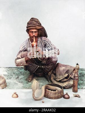 Snake charmer with snake, India.     Date: circa 1890s Stock Photo