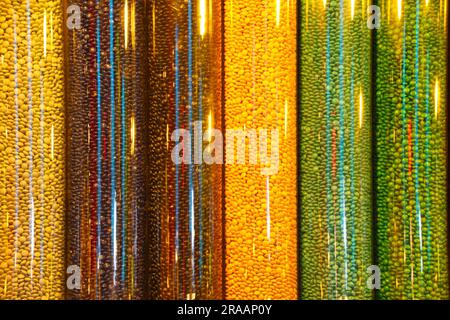 Colorful candies inside shiny cylindrical containers Stock Photo