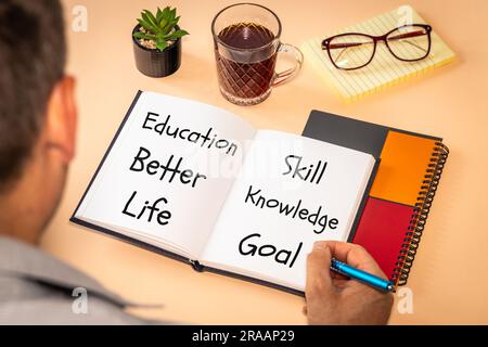 Words written in a notebook, Education better life, skill knowledge, goal, desk, person writing, Concept, Increasing your knowledge, gaining experienc Stock Photo