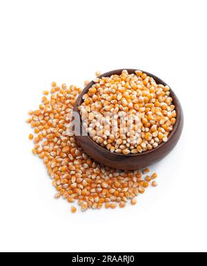 Dried  corn kernels in wooden bowl isolated on white Stock Photo