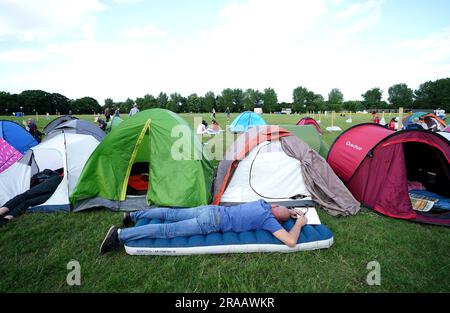 A spectator rests while in the overnight queues ahead of the championships which start on Monday. Picture date: Sunday July 2, 2023. Stock Photo