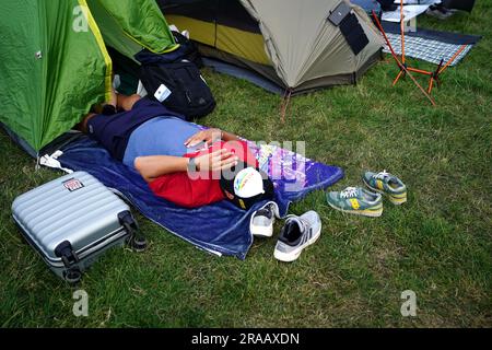 A spectator rests while in the overnight queues ahead of the championships which start on Monday. Picture date: Sunday July 2, 2023. Stock Photo