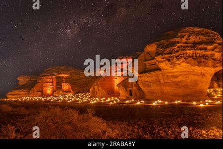 Starlight sky over the ancient nabataean tombs of Hegra city illuminated, night panorama, Al Ula, Saudi Arabia Stock Photo