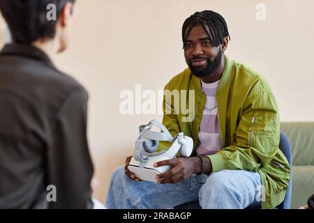 African American man testing VR glasses with psychologist during meeting in office Stock Photo