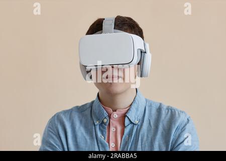 Portrait of young man in wireless VR glasses isolated on beige background Stock Photo