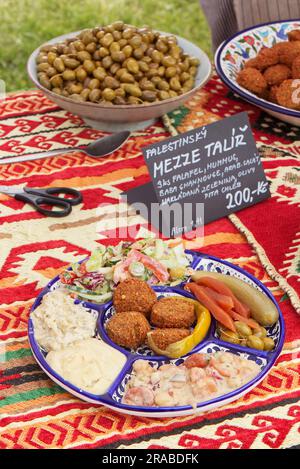 Palestnian Mezze Dish, a selection of Middle Eastern food, falafel, hummus, baba ghannouse, arabic salad, pickles, olives and pita bread. Stock Photo