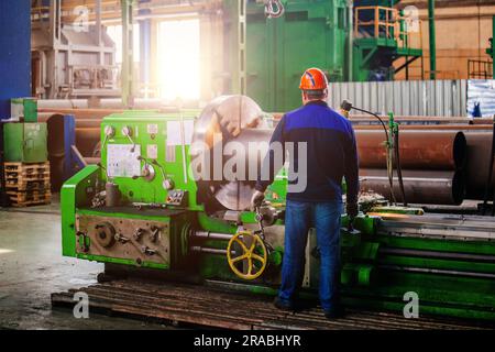 Factory worker working on lathe Stock Photo