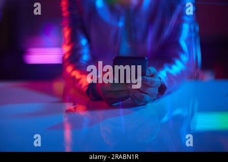 Neon metaverse futuristic concept. Closeup on business woman using smartphone app in office. Stock Photo