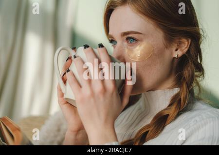 Woman drinking hot beverage and reading book Stock Photo