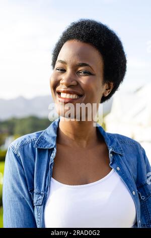 Portrait of happy african american woman on sunny terrace Stock Photo