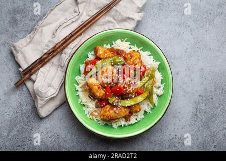 Asian sweet and sour sticky chicken with vegetables stir-fry and rice Stock Photo