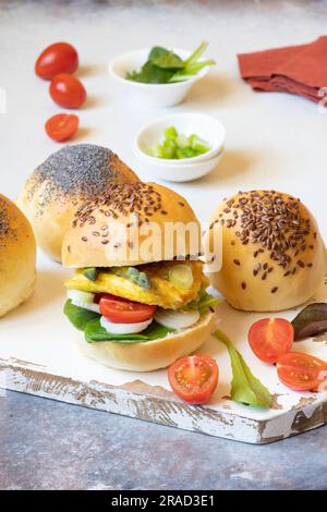 Burger buns with omelette, asparagus spring onions and cherry tomatoes Stock Photo