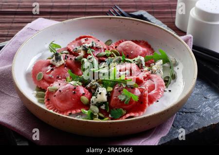 Beetroot tortellini salad with rucola and seeds Stock Photo