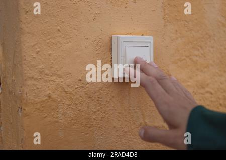 Female hand presses the doorbell button on the street close-up .there is a place for the inscription Stock Photo