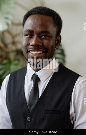 Vertical portrait of handsome black man wearing tux as groom smiling at camera Stock Photo