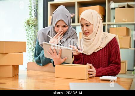 Young Muslim team of online business celebrating together after receiving big orders. Small business concept, coworking Stock Photo